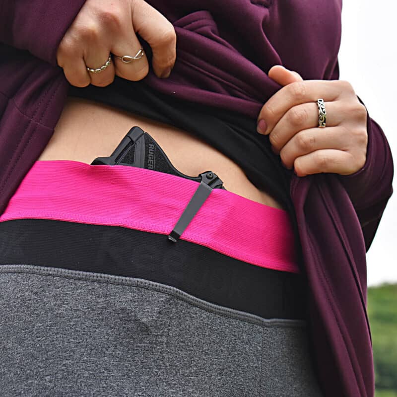 Woman wearing a holster with a Cloudster Pillow for concealed carry comfort.