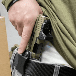 Person holstering a firearm with a Cloudster Pillow holster for training.