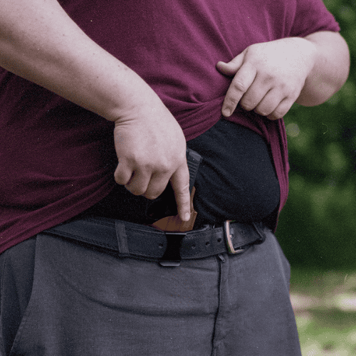 Person using a Cloudster Pillow to comfortably carry a concealed firearm with belly fat.