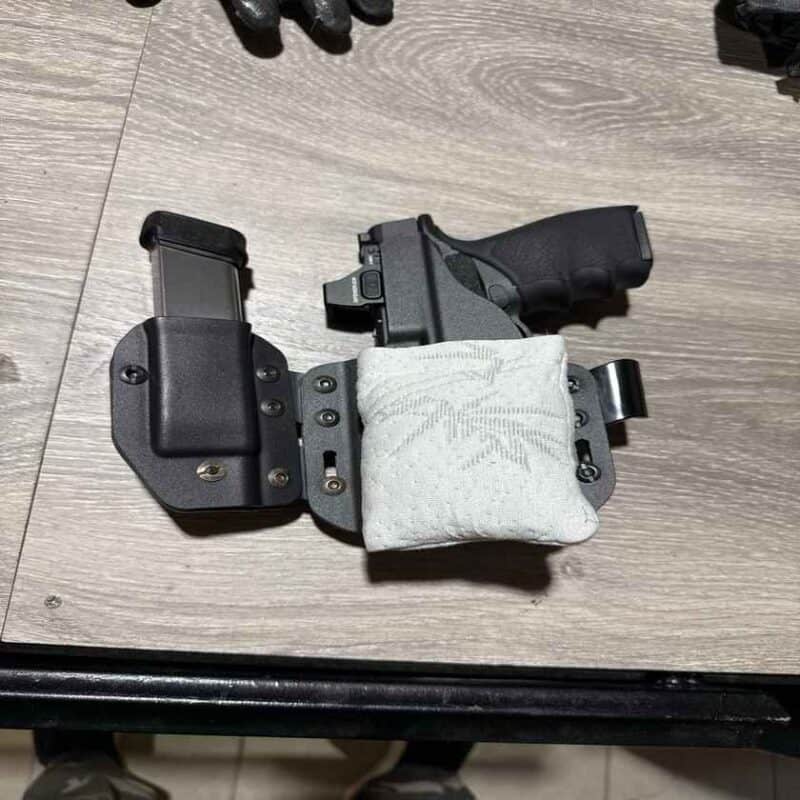 Kydex sidecar holster with an attached mag carrier and a white Cloudster Pillow holster wedge at the muzzle end, set up for comfortable AIWB carry