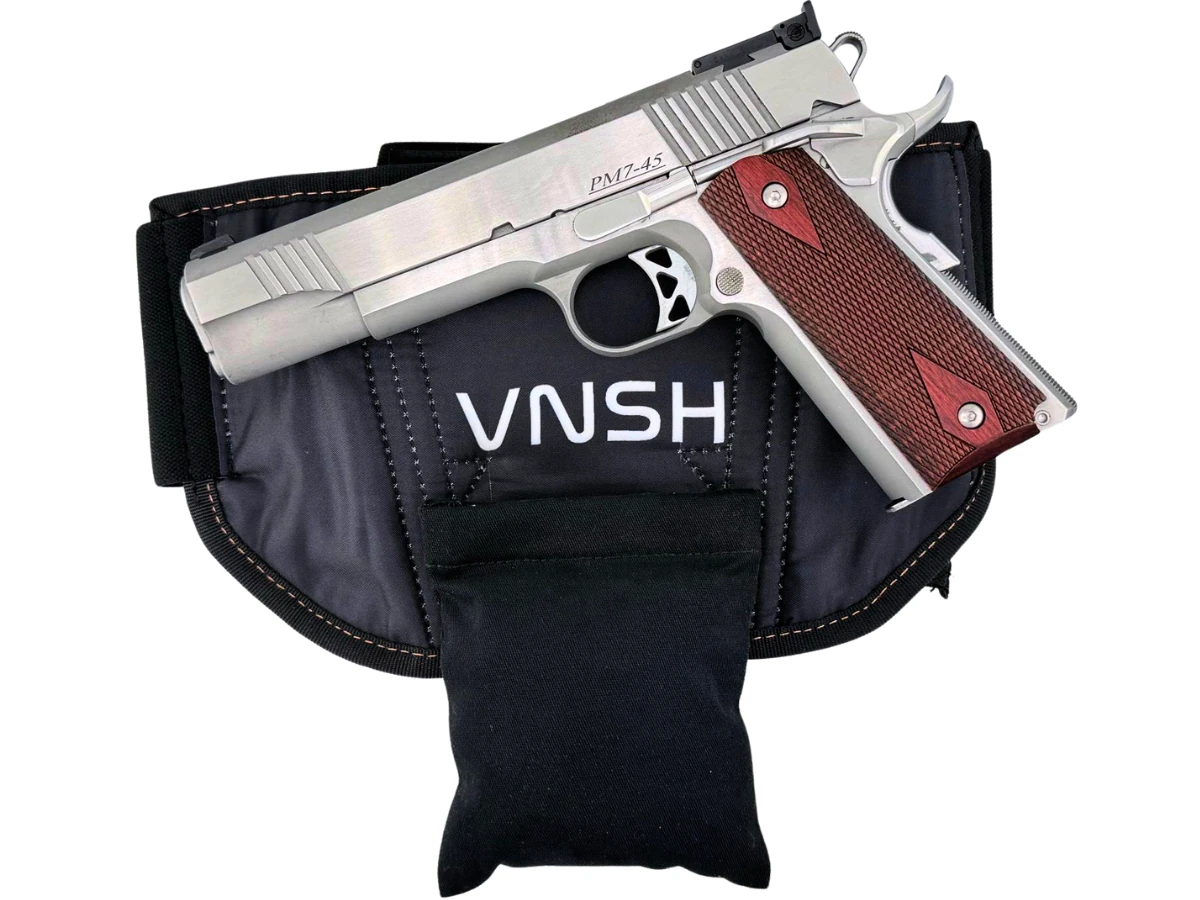 Stainless full-size 1911 resting on a bellyband holster with a Cloudster Pillow attached