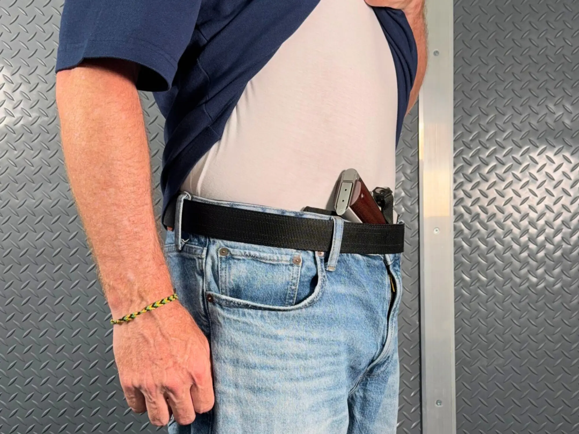 Shirt lifted showing the same 1911 with a Deluxe Cloudster Pillow installed, grip tucked against the body
