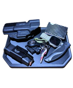 Reinforced carbon fiber EDC dump tray holding a full pocket dump - holstered pistol, spare magazine, keys, folding knife, carbon fiber wallet and a watch