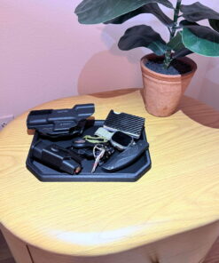 Reinforced carbon fiber EDC dump tray loaded with everyday carry gear on a bedroom nightstand beside a potted plant